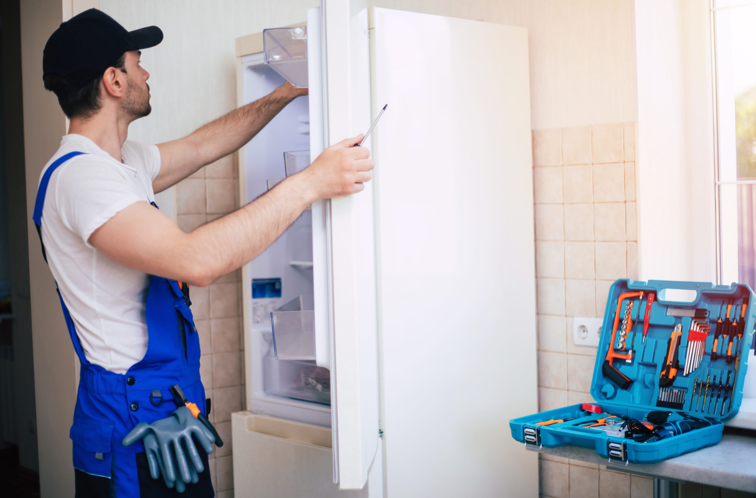 Professional young repairman in worker uniform and cap with mode